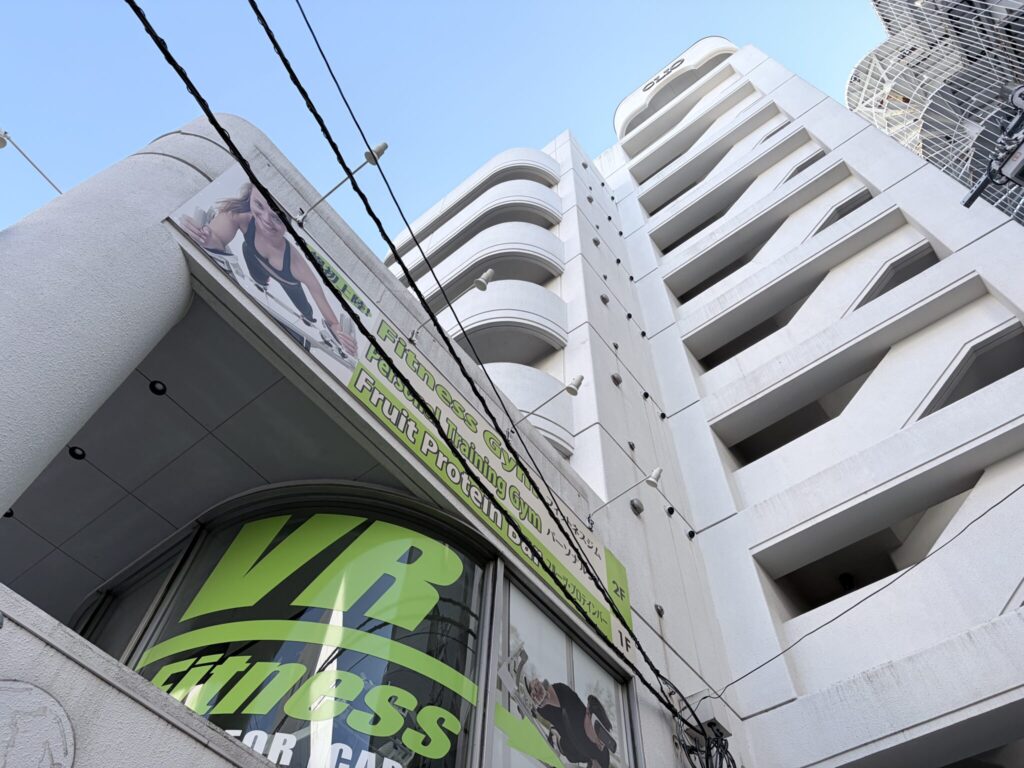 パーソナルトレーニングジムの看板がある建物を見上げた外観