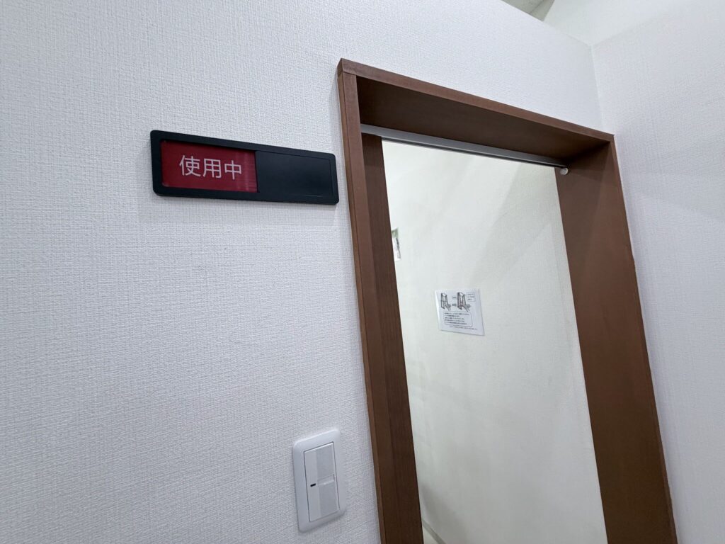 壁に『使用中』の表示板がある個室トレーニングルームの入口